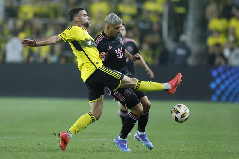 Columbus Crew's Rudy Camacho, left, kicks the ball past Inter Miami's Luis Suarez during the first half of an MLS soccer match Wednesday, Oct. 2, 2024, in Columbus, Ohio. (AP Photo/Jay LaPrete)