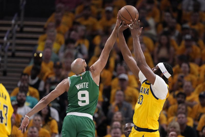 Boston Celtics guard Derrick White (9) blocks a shot by Indiana Pacers center Myles Turner (33) during the first half of Game 3 of the NBA Eastern Conference basketball finals, Saturday, May 25, 2024, in Indianapolis. (AP Photo/Michael Conroy)