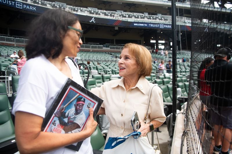 Carla Cohn, (right), speaks with Dr. Ceci Aaron, daughter of baseball legend Hank Aaron, at the USPS commemorative stamp ceremony at Truist Park in Atlanta on Wednesday, July 31, 2024.  (Ziyu Julian Zhu / AJC)