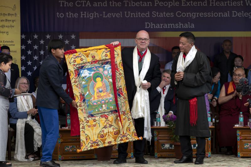Democrat Rep. Jim McGovern, center, is presented with a traditional Tibetan Buddhist painting called Thangka at a public event during which a US delegation led by Republican Rep. Michael McCaul was felicitated by the President of the Central Tibetan Administration Penpa Tsering, right, and other officials at the Tsuglakhang temple in Dharamshala, India, Wednesday, June 19, 2024. (AP Photo/Ashwini Bhatia)