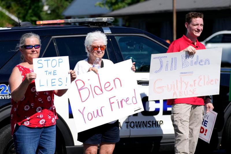 Protesters carry signs in Harrisburg, Pa., as President Joe Biden attends a campaign event Sunday, July 7, 2024. (AP Photo/Stephanie Scarbrough)