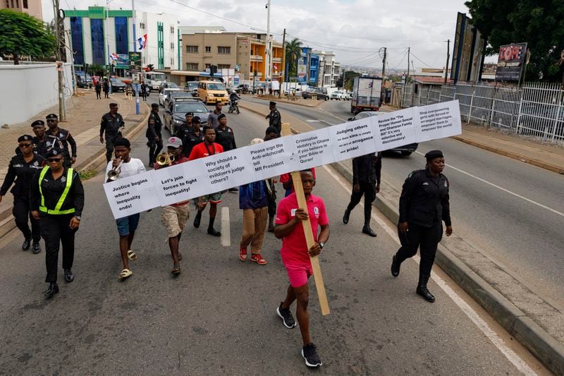 Texas Kadri Moro, the Executive Director of Arise for Justice International, protests with placards nailed on a cross on the street of Accra, Ghana, Thursday Sept 12, 2024. Texas Kadiri Moro is an unusual figure amid the LGBTQ+ rights activists in the coastal West African nation of Ghana. He is heterosexual, married to a woman and a father of six. He is a teacher. And he is a practising Muslim. (AP Photo/Misper Apawu)