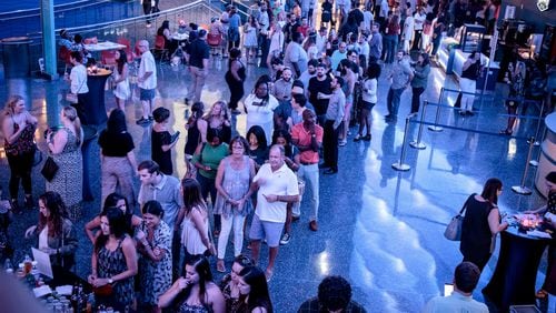 A line forms at one of the bars during the Pacific Barrier Reef exhibit during one of the monthly Sips Under the Sea events at Georgia Aquarium. The Aug. 4 event’s theme will be the Glow Party. STEVE SCHAEFER / SPECIAL TO THE AJC