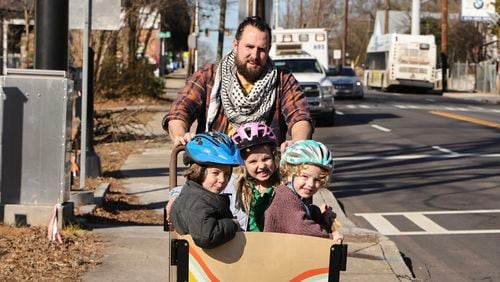 Brendan Horgan rides his bike with his children (left to right)  Bearach 4, Fionnoula, 6, and Ruairi‚Äô, 2, on Metropolitan Parkway in a school zone where cameras have been installed to prevent speeding on Wednesday, Jan. 31, 2024. (Natrice Miller/ Natrice.miller@ajc.com)