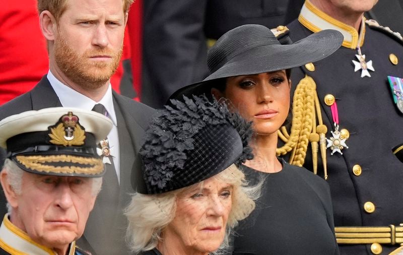 FILE _ Britain's King Charles III, from bottom left, Camilla, the Queen Consort, Prince Harry and Meghan, Duchess of Sussex watch as the coffin of Queen Elizabeth II is placed into the hearse following the state funeral service in Westminster Abbey in central London Monday Sept. 19, 2022. (AP Photo/Martin Meissner, Pool, File)