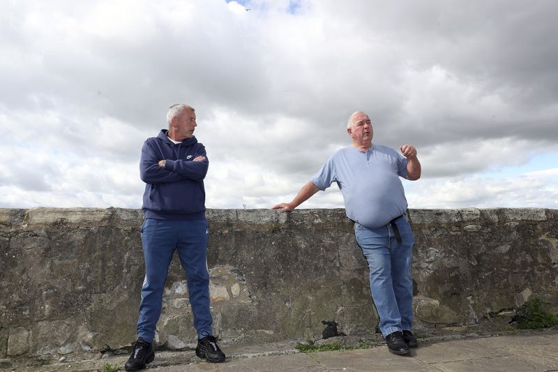 Fisherman Stan Rennie, right, and John Wallace, left, are pictured in Hartlepool, England, Thursday June. 27, 2024. As British voters prepare to choose a new government on Thursday, Hartlepool’s statistics still tell a sobering story. Compared the country as a whole, it has higher unemployment, lower pay, shorter life expectancy, more drug deaths and worse crime rates. (AP Photo/Scott Heppell)
