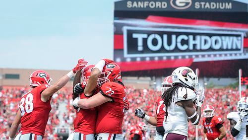 Georgia tight end Jackson Harris (88), tight end Jeb Blazevich (83), and guard Greg Pyke (73) celebrate a touchdown as Louisiana Monroe safety Tre' Hunter (4) walks away during the first half Saturday, Sept., 5, 2015, in Athens.