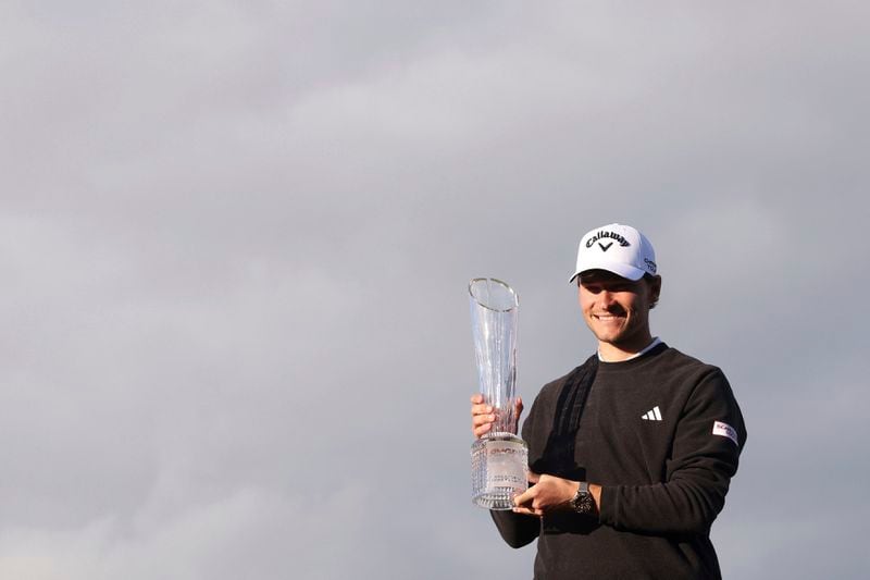 Denmark's Rasmus Hojgaard poses with the trophy after winning the Amgen Irish Open 2024 at Royal County Down in Newcastle, County Down, England, Sunday Sept. 15, 2024. (Peter Morrison/PA via AP)