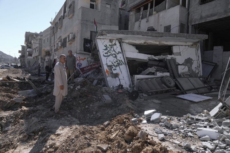 People inspect the destruction following an Israeli forces raid in Tulkarem, West Bank, on Wednesday, Sept. 11, 2024. (AP Photo/Majdi Mohammed)