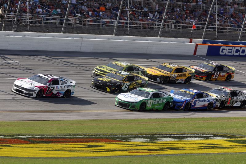 Driver Chris Buescher (17) leads a pack of cars to the end of Stage One during a NASCAR Cup Series auto race at Talladega Superspeedway, Sunday, Oct. 6, 2024, in Talladega, Ala. (AP Photo/ Butch Dill)