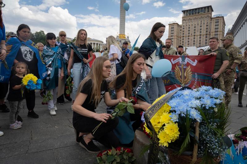Veterans and people lay flowers at a spontaneous memorial to soldiers killed in war with Russia in the Independence square in Kyiv, Ukraine, Thursday, May 23, 2024. (AP Photo/Efrem Lukatsky)