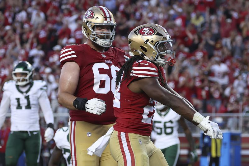 San Francisco 49ers running back Jordan Mason, right, celebrates with offensive tackle Colton McKivitz, front left, after scoring against the New York Jets during the second half of an NFL football game in Santa Clara, Calif., Monday, Sept. 9, 2024. (AP Photo/Jed Jacobsohn)