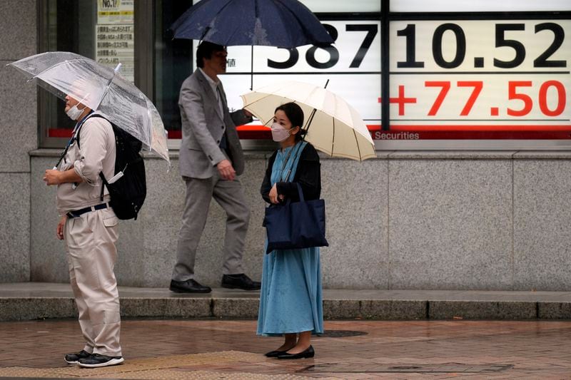People stand in front of an electronic stock board showing Japan's Nikkei 225 index at a securities firm Friday, June 21, 2024, in Tokyo. (AP Photo/Eugene Hoshiko)