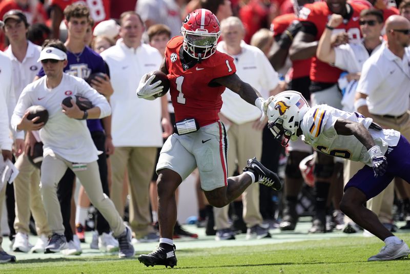 Georgia running back Trevor Etienne (1) fends off Tennessee Tech defensive back Jalin Shephard (6) during the first half of an NCAA college football game Saturday, Sept. 7, 2024, in Athens, Ga. (AP Photo/John Bazemore)