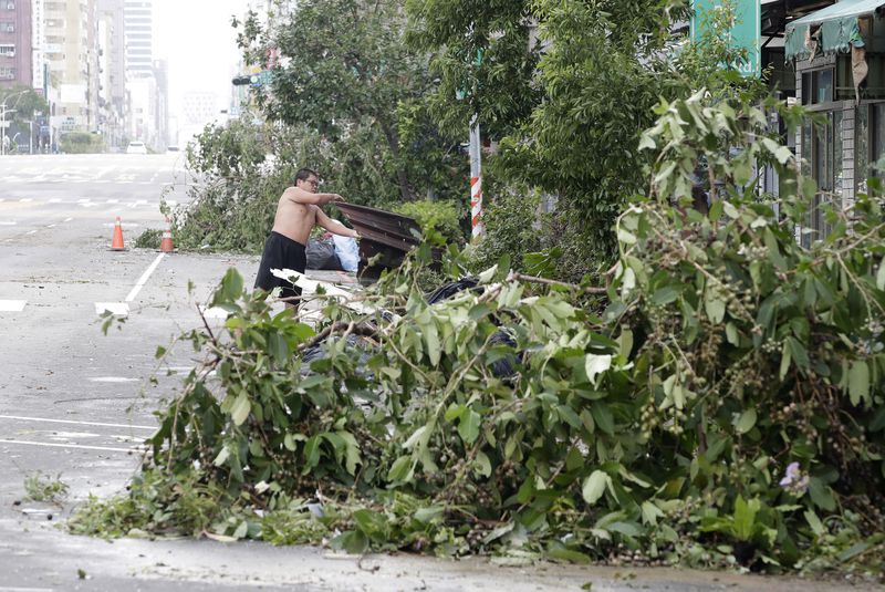 A man clears debris in the aftermath of Typhoon Krathon in Kaohsiung, southern Taiwan, Friday, Oct. 4, 2024. (AP Photo/Chiang Ying-ying)