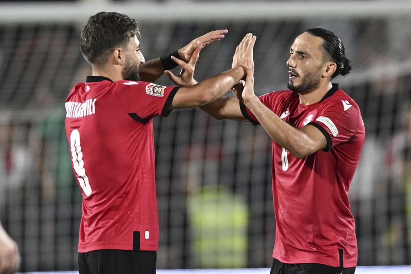 Georgia's Zuriko Davitashvili, left, and Giorgi Kochorashvili celebrate their 4-1 victory in the UEFA Nations League soccer match between Georgia and Czech Republic at the Mikheil Meskhi stadium in Tbilisi, Georgia, Saturday, Sept. 7, 2024. (AP Photo/Tamuna Kulumbegashvili)