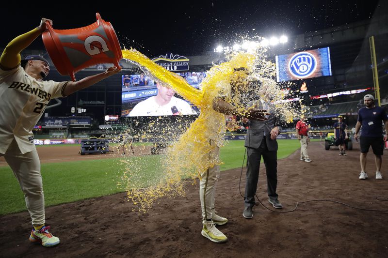 Milwaukee Brewers' Jackson Chourio, right, gets dunked with liquid by Willy Adames, left, after a baseball game against the Los Angeles Dodgers, Wednesday, Aug. 14, 2024, in Milwaukee. (AP Photo/Aaron Gash)