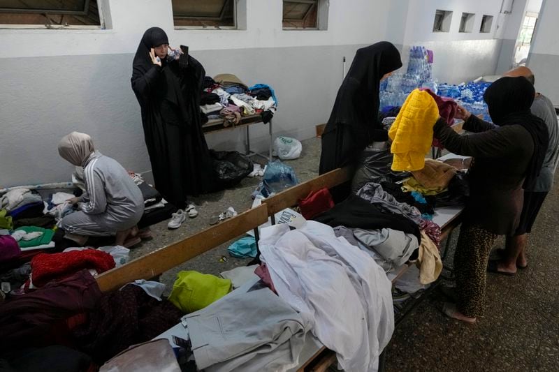 Volunteers distribute clothes to displayed women at a school in Beirut, Thursday, Sept. 26, 2024. (AP Photo/Bilal Hussein)