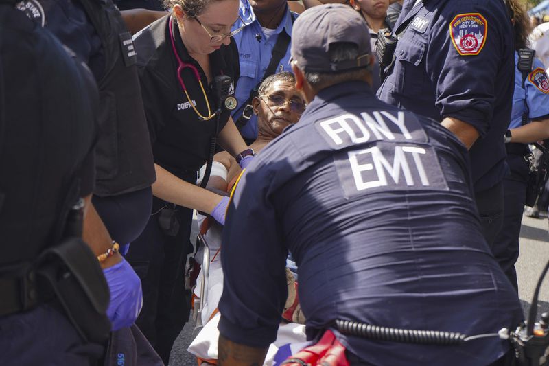 First responders tend to a man injured during a shooting at the West Indian Parade, Monday, Sept. 2, 2024, in the Brooklyn borough of New York. (Nancy Siesel via AP)