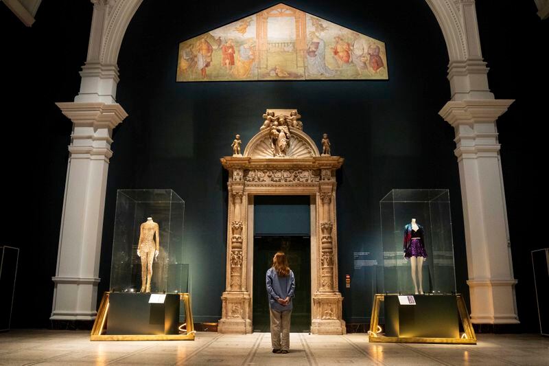 A member of staff views stage costumes from previous concert tours that are displayed at the 'Taylor Swift Songbook Trail Exhibition' in the Raphael Gallery at the Victoria & Albert Museum, on Wednesday, July 24, 2024 in London. (Photo by Scott A Garfitt/Invision/AP)