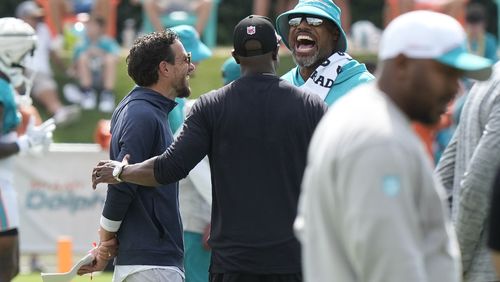 Miami Dolphins coach Mike McDaniel, left, defensive coordinator Anthony Weaver, right, and Falcons coach Raheem Morris, center, share a laugh during a joint practice at the team's practice facility, Tuesday, Aug. 6, 2024, in Miami Gardens, Fla. (AP Photo/Marta Lavandier)