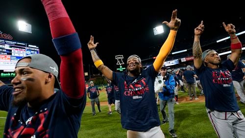 Atlanta Braves' Orlando Arcia, from left, Ronald Acuna Jr. and Eddie Rosario celebrate after clinching their sixth consecutive NL East title by defeating the Philadelphia Phillies in a baseball game, Wednesday, Sept. 13, 2023, in Philadelphia. (AP Photo/Matt Slocum)