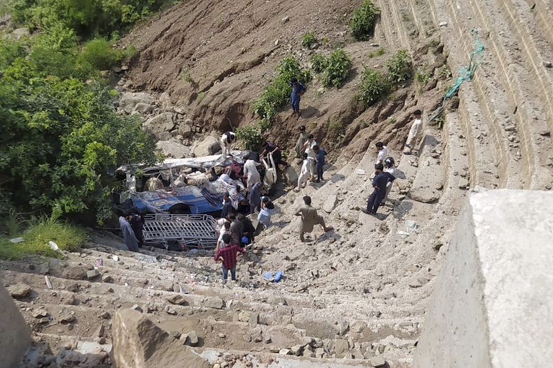 Volunteers recover the bodies and wounded passengers from a damaged bus fell into a ravine, near Kahuta, Pakistan, Sunday, Aug. 25, 2024. (AP Photo)