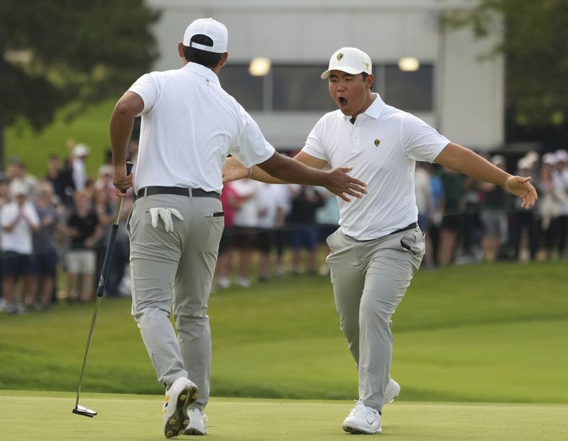 International team members Tom Kim, right, celebrates with partner Si Woo Kim, both of South Korea, after winning the 12th hole during the third round at the Presidents Cup golf tournament at Royal Montreal Golf Club in Montreal Saturday, Sept. 28, 2024. (Christinne Muschi/The Canadian Press via AP)