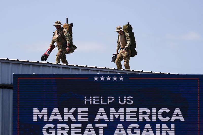 Security gets in position prior to Republican presidential nominee former President Donald Trump speaks at a rally, Wednesday, Aug. 21, 2024, in Asheboro, N.C. Wednesday's event is the first outdoor rally Trump has held since the attempted assassination of the former president. (AP Photo/Julia Nikhinson)