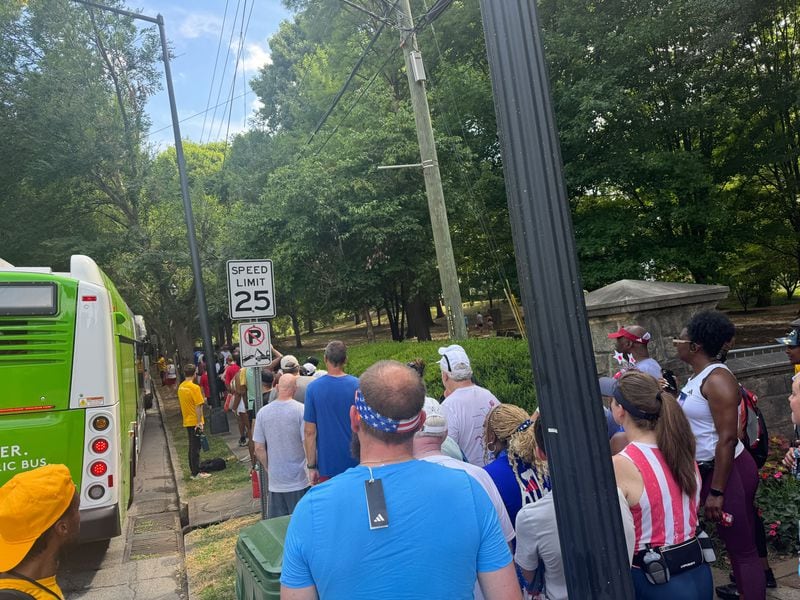 Runners wait to board buses to take them to MARTA stations at the AJC Peachtree Road Race on July 4, 2024.