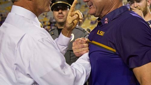 LSU AD Joe Alleva, here congratulating his interim football coach Ed Orgeron, is playing hardball on re-scheduling his game against Florida. (AP Photo/Max Becherer)