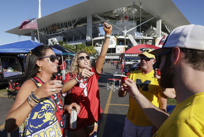 Kerry Skidmore left), her daughter, Maggie, a UGA sophomore cheer along with Michigan fans Nick Hartman and Jim Welch,. Maggie's brother graduated from Michigan.    Bob Andres / bandres@ajc.com