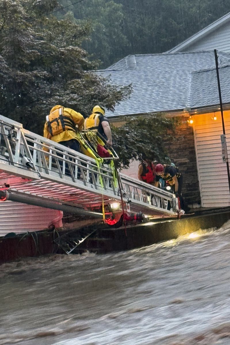 This photo provided by Beacon Hose Co. No. 1, a fire station in Beacon Falls, Connecticut, shows members of Beacon Hose Co. rescuing people from the Brookside Inn in Oxford, Conn., Sunday, Aug. 18, 2024. (Beacon Hose Co via AP)