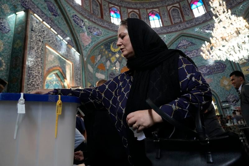 A woman casts her ballot during the Iranian presidential election at a polling station in Tehran, Iran, Friday, June 28, 2024. Iranians were voting Friday in a snap election to replace the late President Ebrahim Raisi, killed in a helicopter crash last month, as public apathy has become pervasive in the Islamic Republic after years of economic woes, mass protests and tensions in the Middle East. (AP Photo/Vahid Salemi)