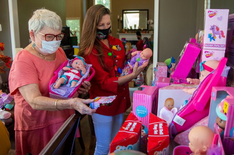 Volunteer Valerie Nelson and Marika Chasse prepare items for packing at the Chasse's home in Johns Creek. For the past six years, the Chasses have hosted a packing party for Operation Christmas Child shoeboxes, a project of Samaritan's Purse. Friends and neighbors will help pack 1,000 shoeboxes. PHIL SKINNER FOR THE ATLANTA JOURNAL-CONSTITUTION.