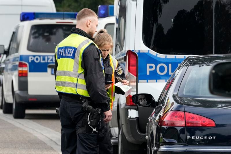 German police check the details of a French car near the border to Belgium in Aachen, Germany, Monday, Sept. 16, 2024, as Germany begins carrying out checks at all its land borders. (AP Photo/Martin Meissner)