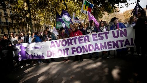 Demonstrators hold a banner reading: Abortion is a fundamental right, as they march in support of the right to abortion for women across the world, in Paris, Saturday, Sept. 28, 2024. (AP Photo/Christophe Ena)