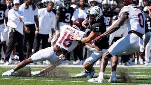 Vanderbilt quarterback Diego Pavia (2) runs the ball against Virginia Tech safety Mose Phillips III (18) and linebacker Keli Lawson (0) during overtime of an NCAA college football game Saturday, Aug. 31, 2024, in Nashville, Tenn. (AP Photo/George Walker IV)