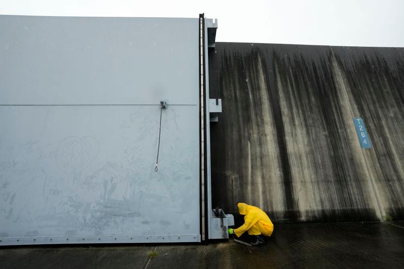 Workers from the Southeast Louisiana Flood Protection Authority-West close floodgates along the Harvey Canal, just outside the New Orleans city limits, in anticipation of Tropical Storm Francine, in Harvey, La., Tuesday, Sept. 10, 2024. (AP Photo/Gerald Herbert)