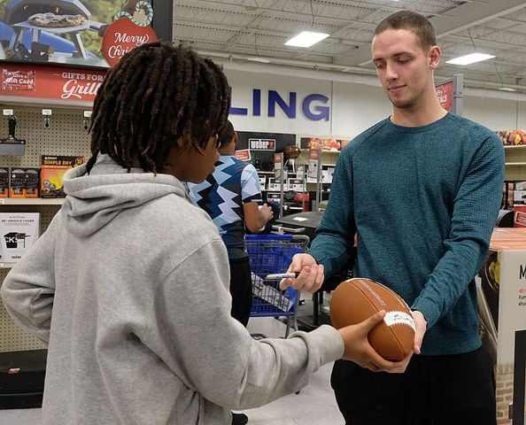Ryan Little, 11,  gets his football signed by UGA quarterback Carson Beck during the Boys and Girls Club shopping spree at Academy. Carson Beck was on site at an Athens Academy store Sunday December 17, 2023, to give out gift cards to lucky members of area Boys and Girls Clubs. Academy contributed $200 for each child and he kicked in $135 more of his own money to help families out. 

credit: Nell Carroll for the AJC