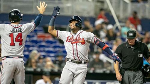 Atlanta Braves center fielder Ronald Acuna celebrates with teammate Matt Joyce (14) after they both scored Acuna's three-run home run to tie the game in the ninth inning Sunday, June 9, 2019, against the Marlins at Marlins Park in Miami.