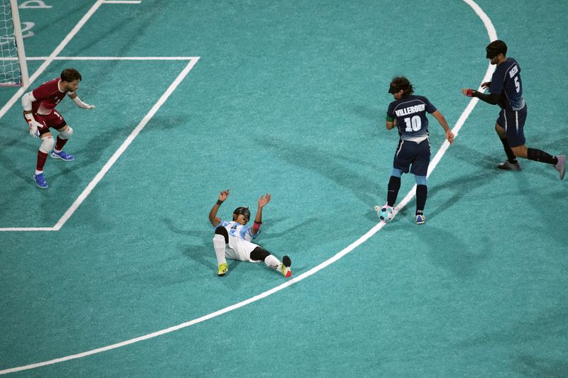 Argentina's Osvaldo Fernandez lies on the floor next to France's Frederic Villeroux, second right, during the blind football gold medal match at the 2024 Paralympics, Saturday, Sept. 7, 2024, in Paris, France. (AP Photo/Christophe Ena)