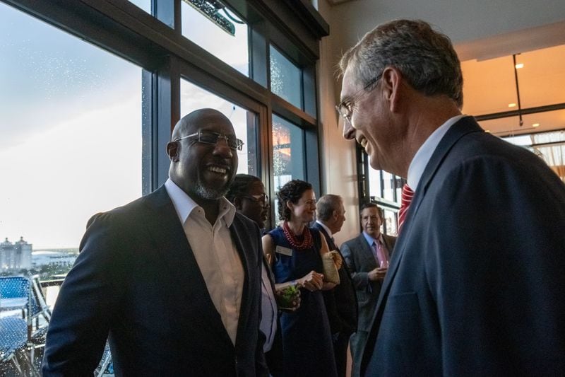 U.S. Raphael Warnock (left), D-Ga, shares a moment with Georgia Secretary of State Brad Raffensperger at an AJC event in Savannah on Monday.