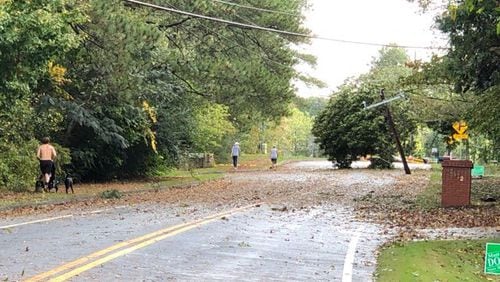 A tilting tree and downed power line on Sewell Mill Road near Johnson Ferry Road in east Cobb. (Photo by Rich Danielson / for the AJC )