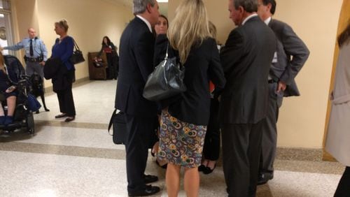 Rep. John Carson, R-Marietta (left), huddles with lobbyists under the Gold Dome after a hearing on House Bill 217, which attempted to increase the annual cap on tax credits for private school scholarships.