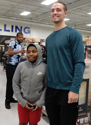 Davidian Colbert, 12, poses with UGA Quarterback Carson Beck who was on site at an Athen Academy store Sunday December 17, 2023, to give out gift cards to lucky members of area Boys and Girls Clubs. Academy Sports and Outdoors contributed $200 for each child and he kicked in $135 more of his own money to help families out. 

credit: Nell Carroll for the AJC