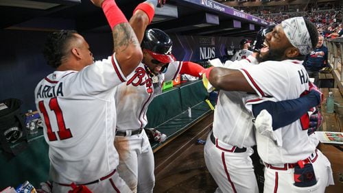 Atlanta Braves’ Orlando Arcia (11) and Michael Harris II (23) celebrate with Austin Riley after his two-run home run against the Philadelphia Phillies during the eighth inning of NLDS Game 2 in Atlanta on Monday, Oct. 9, 2023.   (Hyosub Shin / Hyosub.Shin@ajc.com)