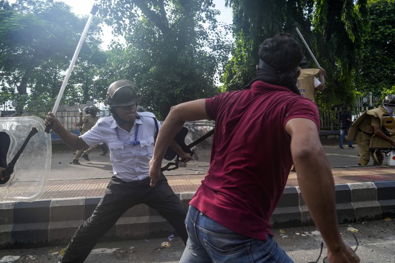 A policeman hits a protester against the rape and murder of a resident doctor at a government hospital earlier this month, in Kolkata, India, Tuesday, Aug. 27, 2024. (AP Photo/Bikas Das)