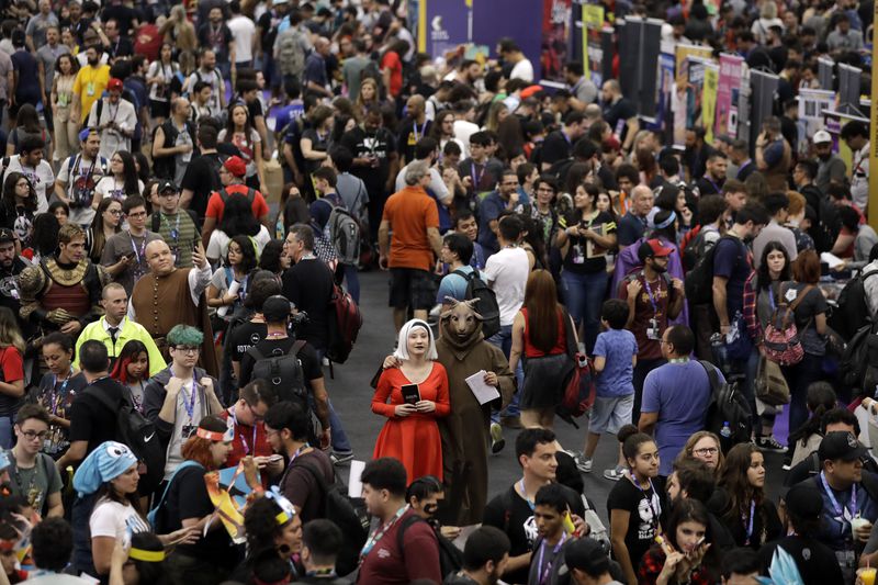 FILE - People attend the Comic Con Experience fair in Sao Paulo, Brazil on Dec. 6, 2018. (AP Photo/Andre Penner, File)