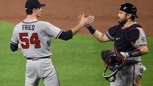 Atlanta Braves starting pitcher Max Fried (54) is greeted by catcher Travis d'Arnaud after pitching a four-hitter against the Baltimore Orioles in a baseball game, Friday, Aug. 20, 2021, in Baltimore. The Braves won 3-0. (AP Photo/Terrance Williams)